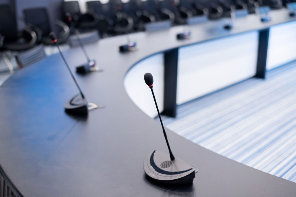 Close-up of microphones in an empty meeting room at a press conference.